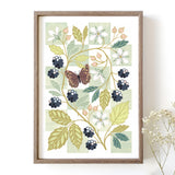 A framed botanical art print featuring a butterfly, blackberries, white flowers, and green leaves on a pale green chequered background.