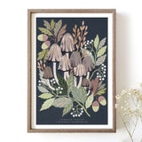An art print featuring a cluster of common inkcap mushrooms with surrounding green leaves and dark background in a wooden frame.