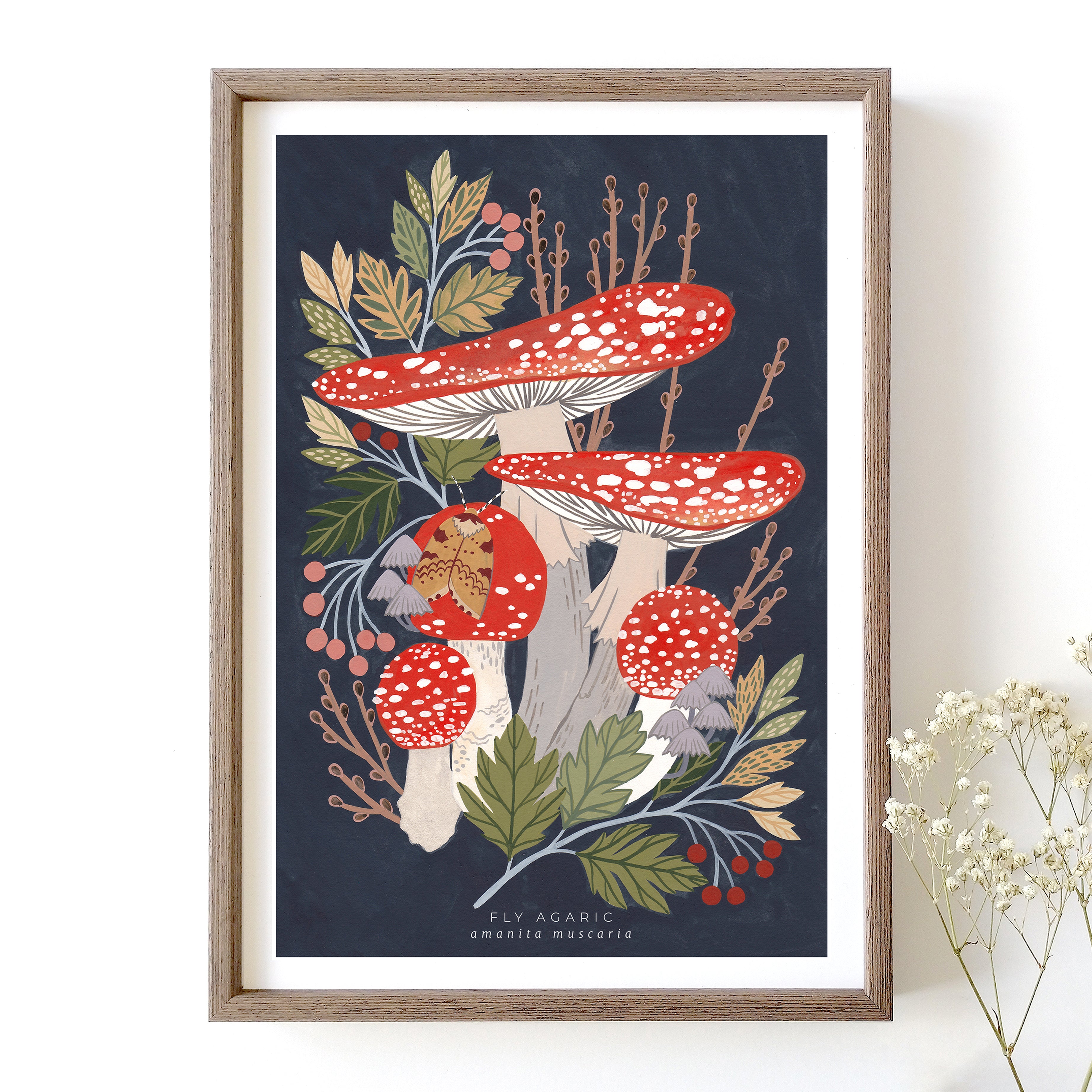 A framed art print featuring a colourful illustration of fly agaric mushrooms and woodland foliage.