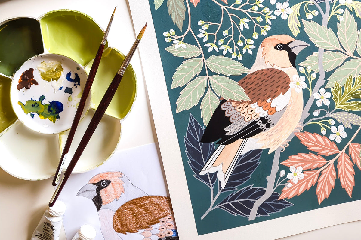 A painting featuring a stylized bird illustration with leaves and flowers, styled on a tabletop with paint palettes, paintbrushes, and a paint tube.