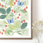 Framed botanical wall art print with strawberries and blue butterflies against a white and green chequerboard background.
